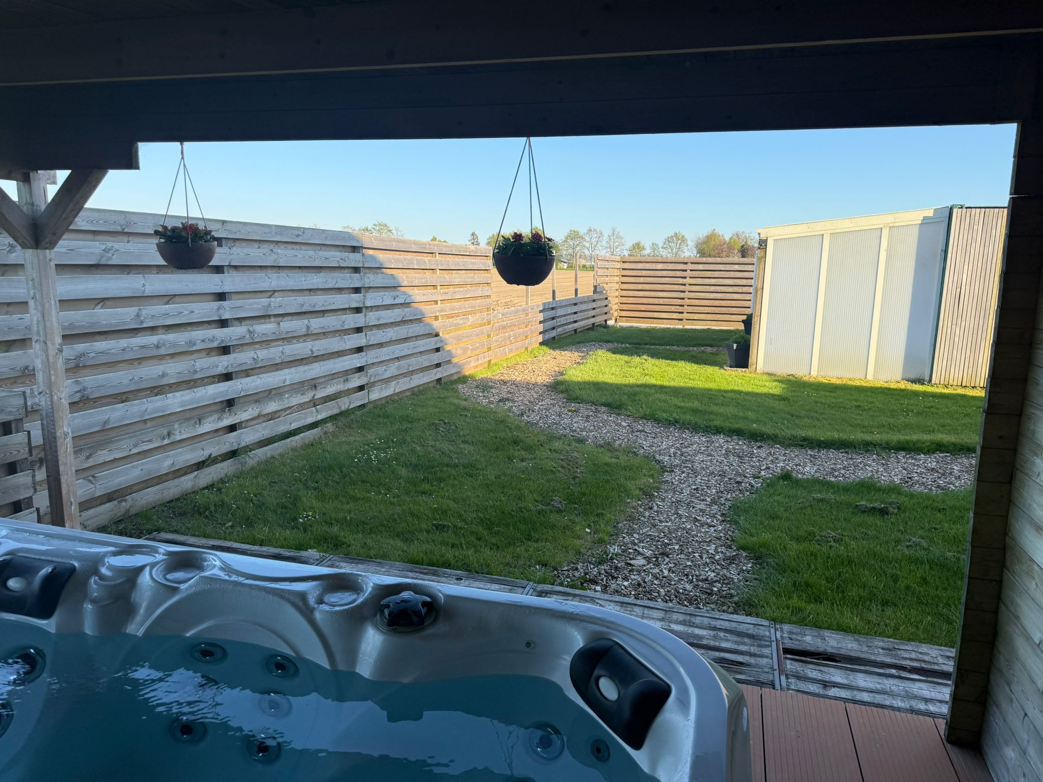 Jacuzzi met uitzicht op de omheinde tuin met gazon